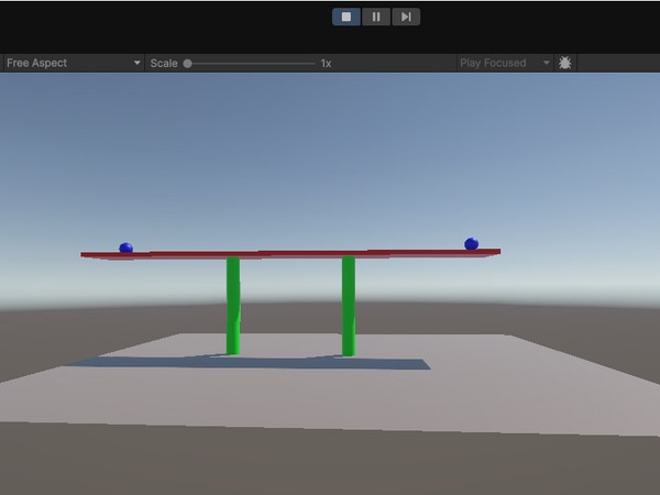 red block being held up by three green cylinder legs and holding two blue balls